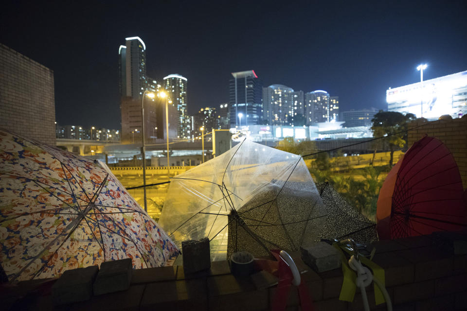 In this Thursday, Nov. 21, 2019, photo, umbrellas are left at Hong Kong Polytechnic University in Hong Kong. Most of the protesters who took over the university have left following clashes with police, but an unknown number have remained inside, hoping somehow to avoid arrest. (AP Photo/Vincent Thian)