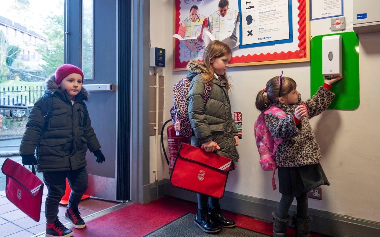 Pupils sanitise their hands as they arrive at Inverkip Primary School - Jane Barlow /PA