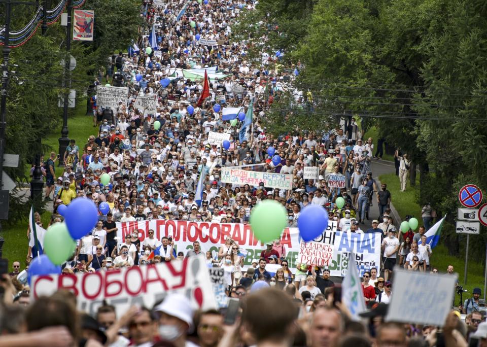 People hold various posters supporting Khabarovsk region's governor Sergei Furgal, during an unsanctioned protest in support of Sergei Furgal, who was interrogated and ordered to be held in jail for two months, in Khabarovsk, 6,100 kilometers (3,800 miles) east of Moscow, Russia, Saturday, July 25, 2020. Many thousands marched across Khabarovsk to protest the arrest of the region's governor on murder charges, continuing a wave of protests that has lasted for two weeks. (AP Photo/Igor Volkov)