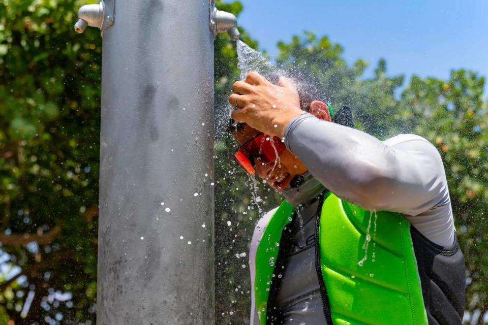 Beachgoer Sergei lazovskiy cools off under the shower on a sunny and hot day at the Haulover Park beach on May 28, 2024. There have been regular heat advisories throughout the summer so far in South Florida.