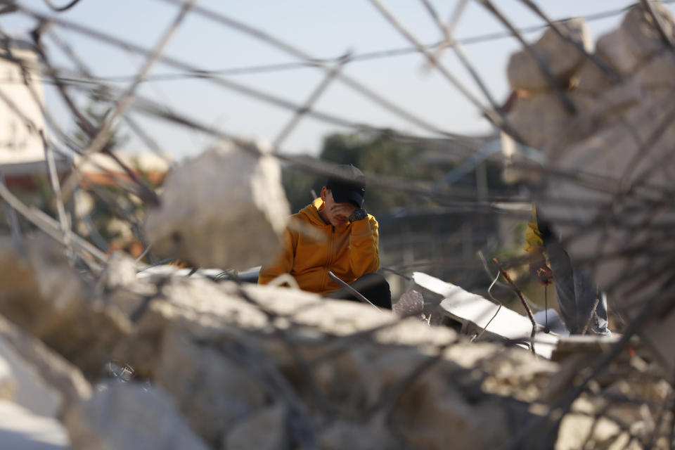 A Palestinian reacts in the rubble of a house after it was demolished by the Israeli army in the West Bank city of Jenin, Thursday, Feb. 6, 2020. Israeli military spokesman Lt. Col. Jonathan Conricus said troops were carrying out the demolition of a home belonging to a militant allegedly involved in a deadly attack. (AP Photo/Majdi Mohammed)