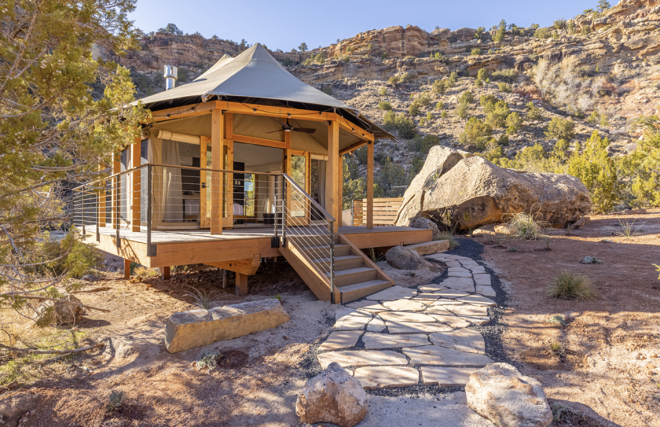 small glamping hut with mountains behind it