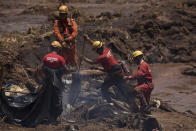 Firefighters looks for victims inside a vehicle days after a dam collapse in Brumadinho, Brazil, Monday, Jan. 28, 2019. Firefighters on Monday carefully moved over treacherous mud, sometimes walking, sometimes crawling, in search of survivors or bodies four days after a dam collapse that buried mine buildings and surrounding neighborhoods with iron ore waste. (AP Photo/Leo Correa)