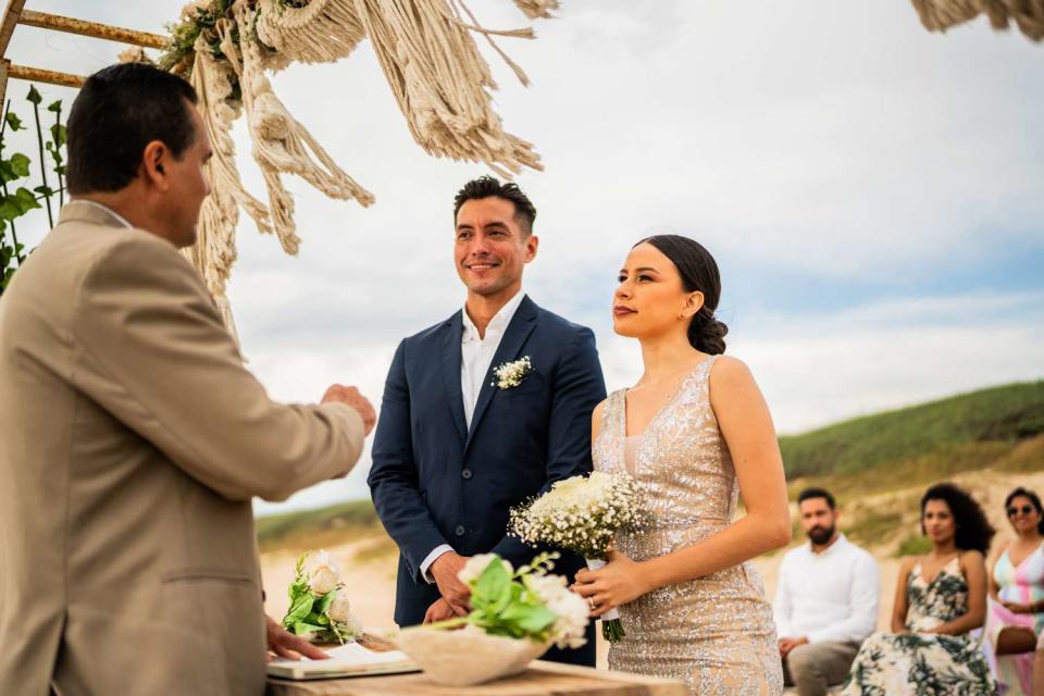 <p>Getty</p> Groom and bride in wedding ceremony on a beach