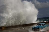 Un conductor maniobra su vehículo clásico por el Malecón de La Habana, al tiempo que un fuerte oleaje se presenta por cuenta del paso del huracán Sandy por Cuba, el 25 de octubre de 2012. AP Photo/Ramon Espinosa