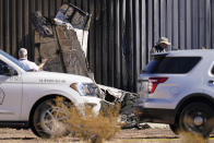 People investigate a deadly twin-engine plane crash Thursday, Oct. 29, 2020, in Las Vegas. A twin-engine aircraft crashed shortly after takeoff Thursday in suburban Las Vegas, killing two people and igniting a fire that damaged a construction trailer from which a man escaped while choking on fuel fumes. (AP Photo/John Locher)