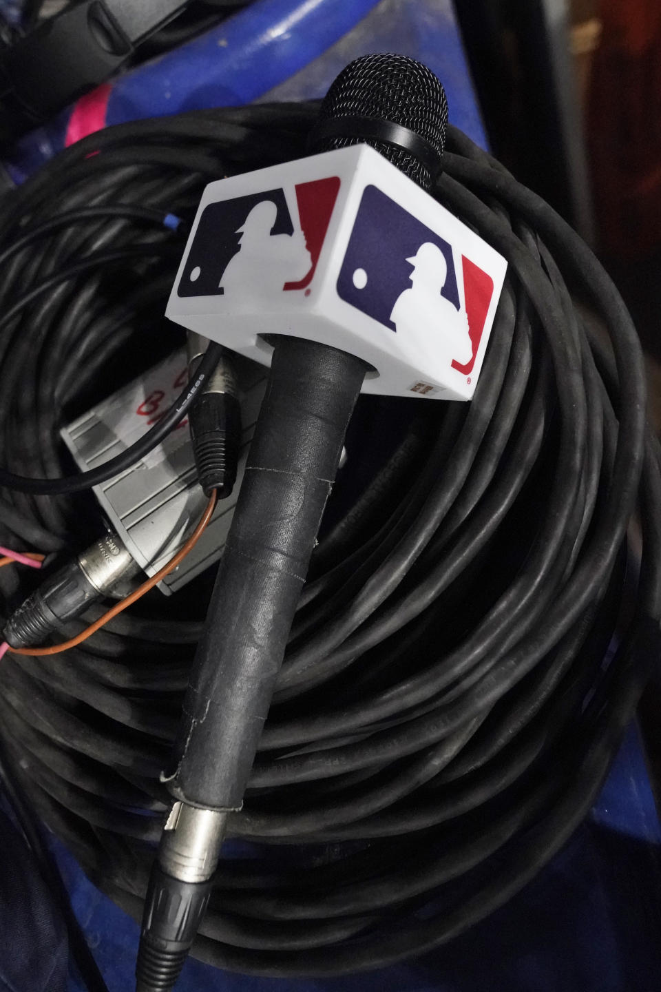 A microphone belonging to a field reporter for the San Diego Padres sits on top of audio cables during a baseball game between the Miami Marlins and the Padres, Wednesday, May 31, 2023, in Miami. Major League Baseball took over broadcasts of the Padres' games Wednesday. (AP Photo/Wilfredo Lee)
