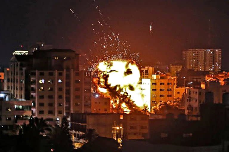 El fuego sale de un edificio golpeado por un ataque aéreo israelí en la Franja de Gaza, en medio de la escalada de violencia israelí-palestina