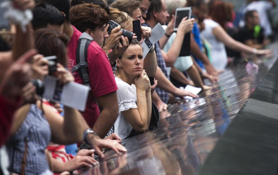 A woman reflects (C) while standing at the South Pool of the 9/11 Memorial at Ground Zero, the site of the September 11, 2001 attacks, in New York September 10, 2013. Wednesday marks the 12th anniversary of the attacks on September 11, 2001. (REUTERS/Adrees Latif)