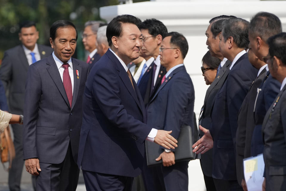 South Korean President Yoon Suk Yeol, center, shakes hands with Indonesian Coordinating Minister for Economics Affairs Airlangga Hartarto as he is introduced to the cabinet ministers by President Joko Widodo, left, upon arrival ahead of their meeting at Merdeka Palace in Jakarta, Indonesia, Friday, Sept. 8, 2023. (AP Photo/Achmad Ibrahim)