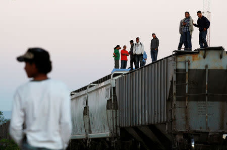 FILE PHOTO: Central American migrants stand atop wagons while waiting for the freight train "La Bestia", or the Beast, to travel to north Mexico to reach and cross the U.S. border, in Arriaga in the state of Chiapas January 10, 2012. REUTERS/Jorge Luis Plata/File Photo