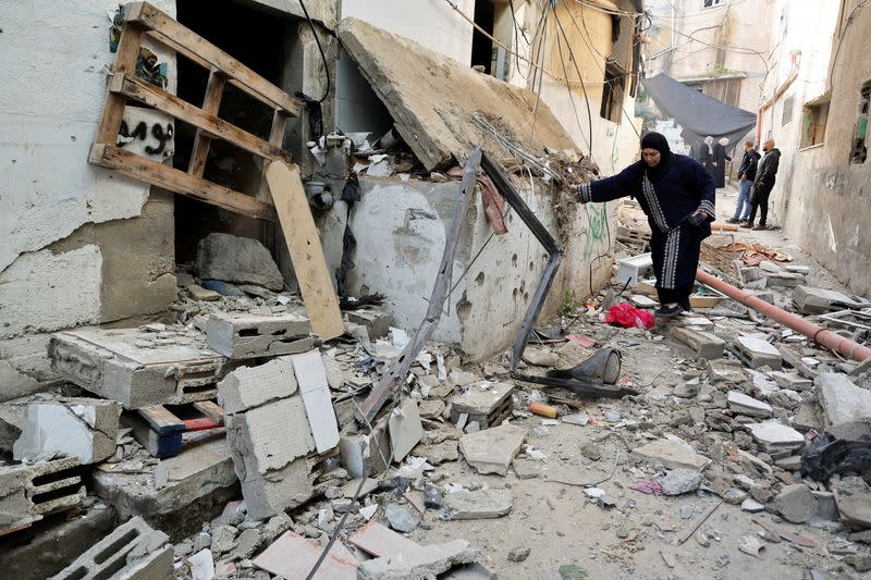 Palestinians check the damage in a street in the aftermath of an Israeli raid in Jenin