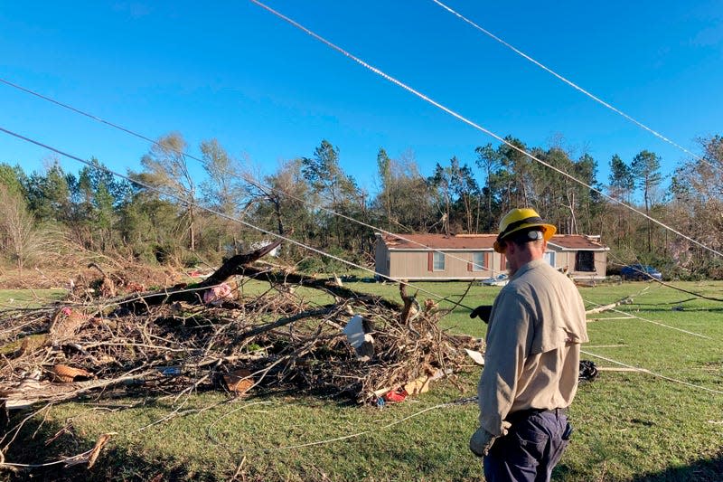 A utility worker observes damage in Keithville, Louisiana. 