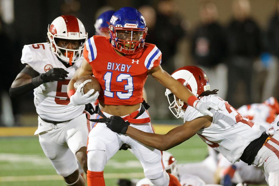 Bixby's Kordell Gouldsby runs the ball under pressure from Owasso's Jaylen Jones in the Class 6A-I state championship football game last season at Chad Richison Stadium in Edmond.