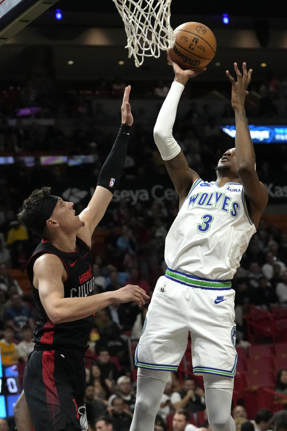 Minnesota Timberwolves forward Jaden McDaniels (3) goes to the basket as Miami Heat guard Tyler Herro defends during the first half of an NBA basketball game, Monday, Dec. 18, 2023, in Miami. (AP Photo/Lynne Sladky)