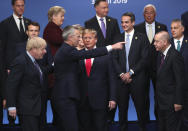 FILE - In this Wednesday, Dec. 4, 2019 file photo Britain's Prime Minister Boris Johnson, left, looks on as NATO Secretary General Jens Stoltenberg, center front left, speaks with U.S. President Donald Trump, center front right, during a ceremony event at a NATO leaders meeting at The Grove hotel and resort in Watford, Hertfordshire, England. (AP Photo/Francisco Seco, File)