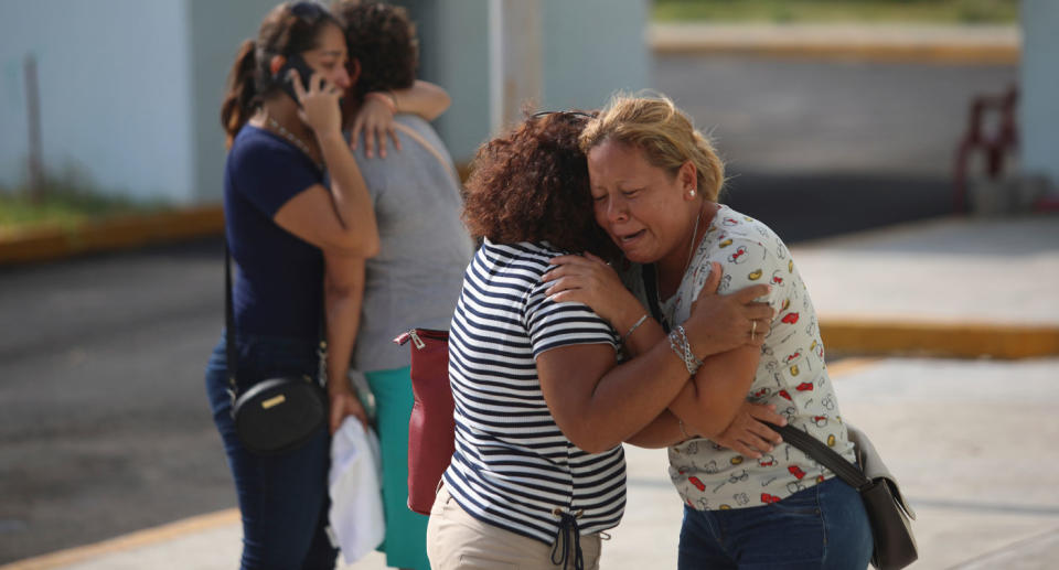 Family of people killed in Mexican bar fire cry and hug each other after 26 killed.