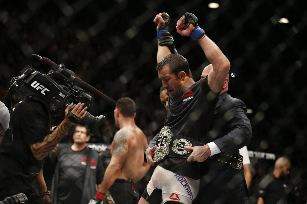 Luke Rockhold, right, reacts after defeating Chris Weidman, left, in a middleweight 
championship mixed martial arts bout at UFC 194, Saturday, Dec. 12, 2015, in Las Vegas. (AP Photo/John Locher)