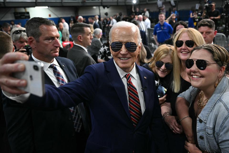 President Joe Biden takes a selfie with supporters after speaking about the PACT Act, which expands coverage for veterans exposed to toxic substances, at a YMCA in Nashua, New Hampshire, on May 21, 2024.