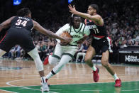 Boston Celtics guard Jrue Holiday, center, tries to drive past Portland Trail Blazers forward Jabari Walker (34) and guard Rayan Rupert (72) during the first half of an NBA basketball game, Sunday, April 7, 2024, in Boston. (AP Photo/Charles Krupa)