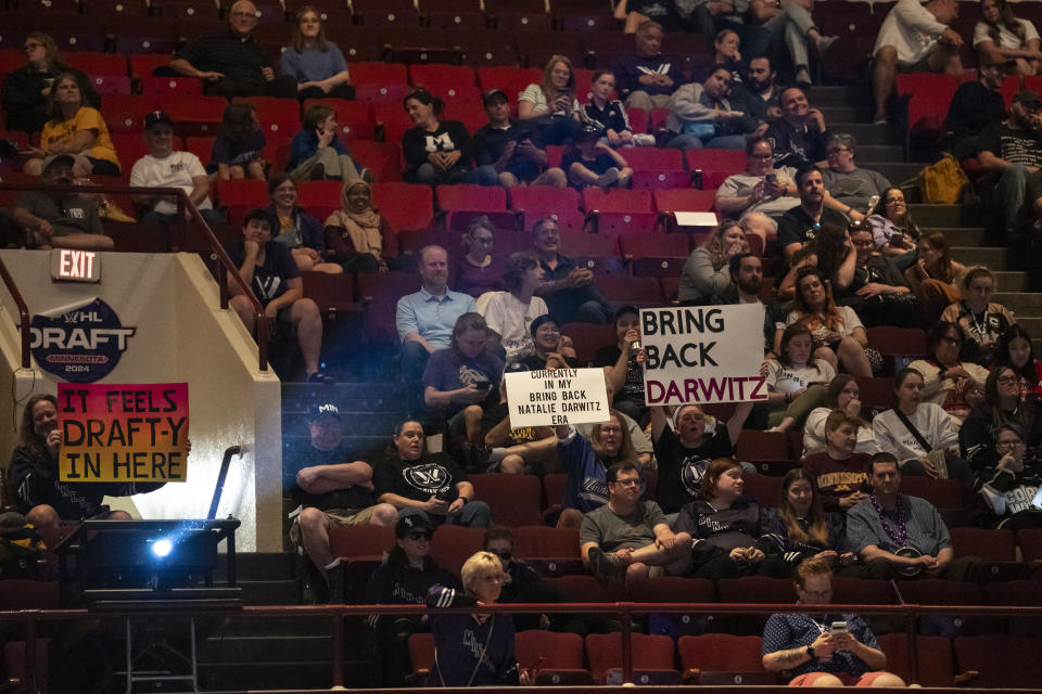 Fans Tina Frederickson and Lisa Fulton hold signs, center right, about the removal of general manager Natalie Darwitz from PWHL Minnesota, during the PWHL hockey draft in St. Paul, Minn., Monday June, 10, 2024. (Renée Jones Schneider/Star Tribune via AP)