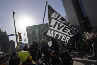 A demonstrator holds up a Black Lives Matter flag outside the Hennepin County Government Center, right, Monday, March 8, 2021, in Minneapolis where the trial for former Minneapolis police officer Derek Chauvin began with jury selection. Chauvin is charged with murder in the death of George Floyd during an arrest last May in Minneapolis. (AP Photo/Jim Mone)