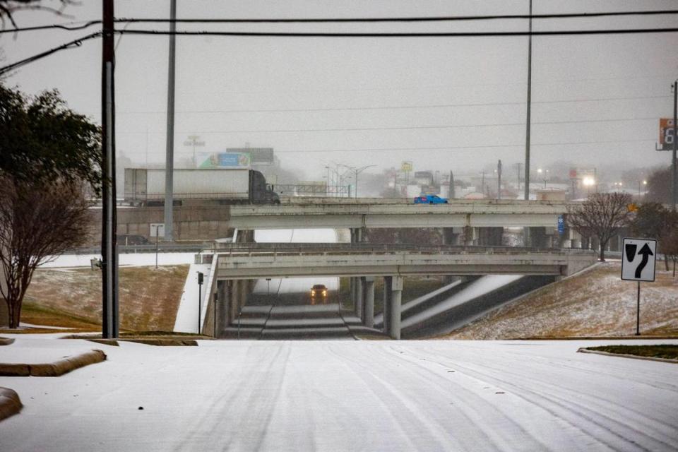 Cars drive over an I-30 underpass with icy weather in Fort Worth on Tuesday, Jan. 31, 2023. Winter storm conditions have extended through Thursday morning as freezing rain continues.