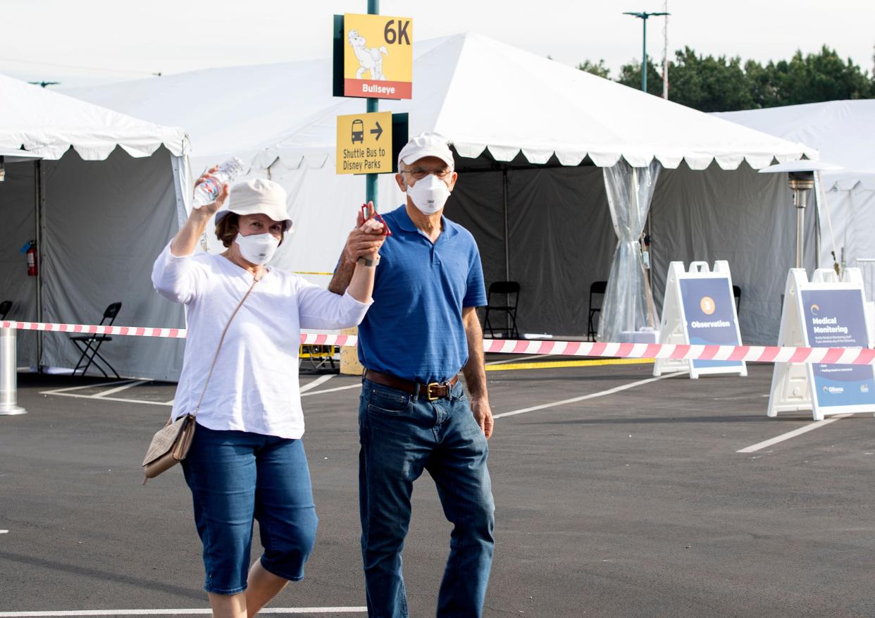 People react as they leave after receiving a COVID-19 vaccine on the opening day of the Disneyland COVID-19 vaccination 