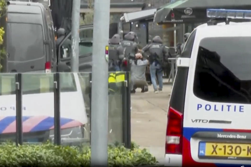 This framegrab from video shows a suspected hostage-taker surrendering to police after a tense hours-long standoff in the central Dutch town of Ede, Netherlands, Saturday, March 30, 2024. Dutch police have detained a man who walked out of a nightclub where hostages were being held after a tense hours-long standoff. They said on X that the last hostage has been released and one person was arrested. The man walked out of the club before being ordered by armed police to kneel with his hands on his head. (AP Photo)