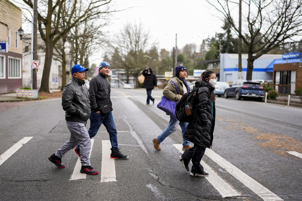 From left, seafarers Richard Zambales and Albert Docuyan walk to take a written driver's license test with community activists and volunteers Jill Mangaliman and Mika Magbanua Monday, Feb. 5, 2024, in Seattle. (AP Photo/Lindsey Wasson)