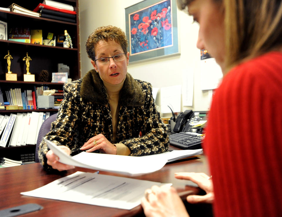 Portia Noel, left, of Premier Mortgage Group of Boulder, helps Leslie Garcia with refinancing. (Photo by Cliff Grassmick/Digital First Media/Boulder Daily Camera via Getty Images)