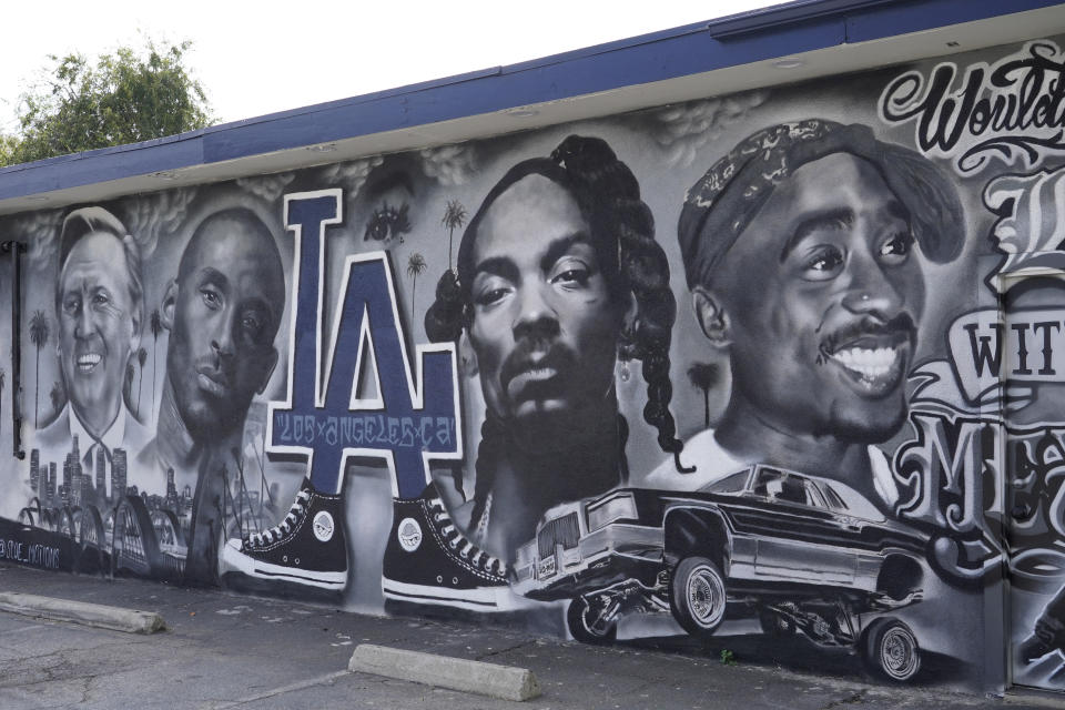 A portion of a mural by artist sloe_motions depicting Vin Scully, Kobe Bryant, Snoop Dogg, and Tupac Shakur is seen on the side of Speedy Auto Tint on Friday, Sept. 29, 2023, in Bellflower, Calif. (AP Photo/Chris Pizzello)