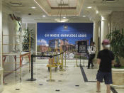 In this Monday, Aug. 19, 2019 photo, a University of Nevada, Reno student walks toward a security guard as renovation work continues in the lobby of the Circus Circus hotel-casino tower in downtown Reno, Nev., that will house roughly 1,300 UNR students after a July gas explosion shut down two major dorms. The non-gambling, non-smoking building that a subsidiary of Circus Circus leased to the university for $21.7 million has been converted into a residence hall exclusively for students through the 2019-2020 school year. (AP Photo/Scott Sonner)