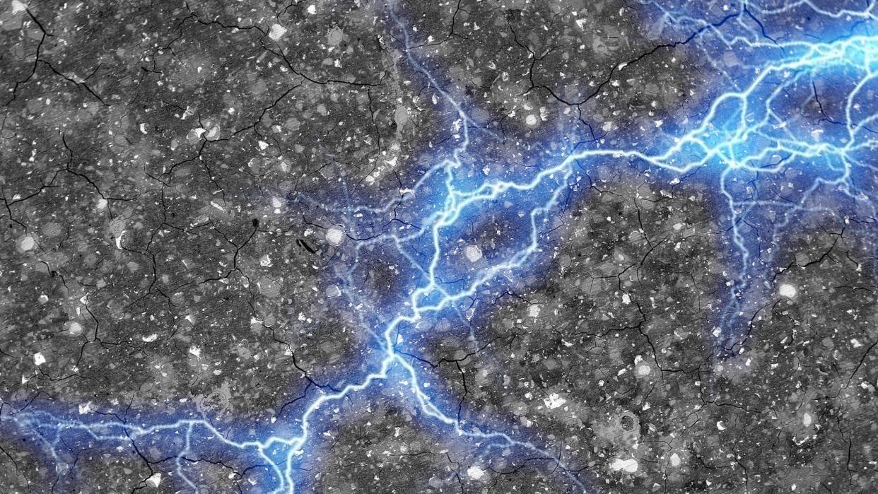 A streak of blue lightning, representing energy, spreads horizontally across a textured cement surface.