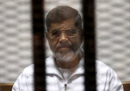 FILE PHOTO: Ousted Egyptian President Mursi is seen behind bars during his trial at a court in Cairo