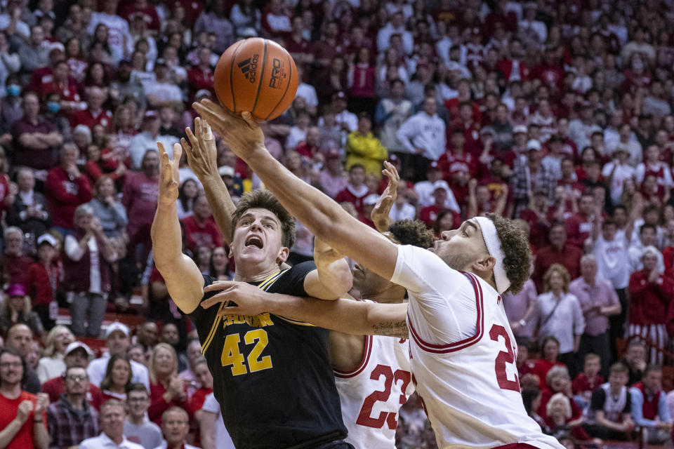 Michigan forward Will Tschetter (42) and Indiana forward Race Thompson (25) battle for a rebound during the first half of an NCAA college basketball game, Sunday, March 5, 2023, in Bloomington, Ind. (AP Photo/Doug McSchooler)