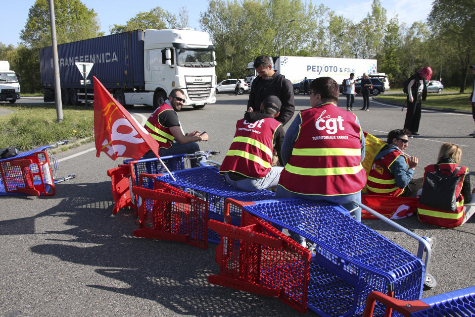 Demonstrators block the access to the Ikea store in protest against the pension reforms in Bayonne, southwestern France, Thursday, April 20, 2023. Union activists stage scattered actions to press France's government to scrap the new law raising the retirement age. (AP Photo/Bob Edme)