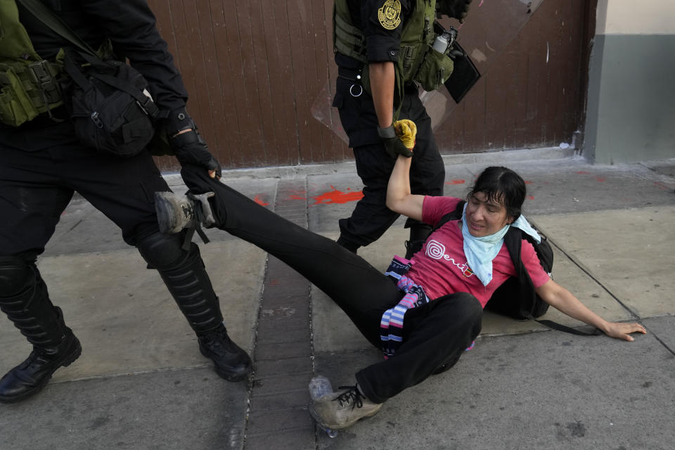 Police drag an anti-government protester in Lima, Peru, Tuesday, Jan. 24, 2023. Protesters are seeking the resignation of President Dina Boluarte, the release from prison of ousted President Pedro Castillo, immediate elections and justice for demonstrators killed in clashes with police. (AP Photo/Martin Mejia)