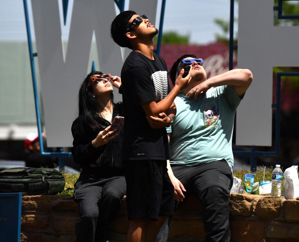 People looks up to view the eclipse at Park Central in downtown Wichita Falls on Monday, April 8, 2024.