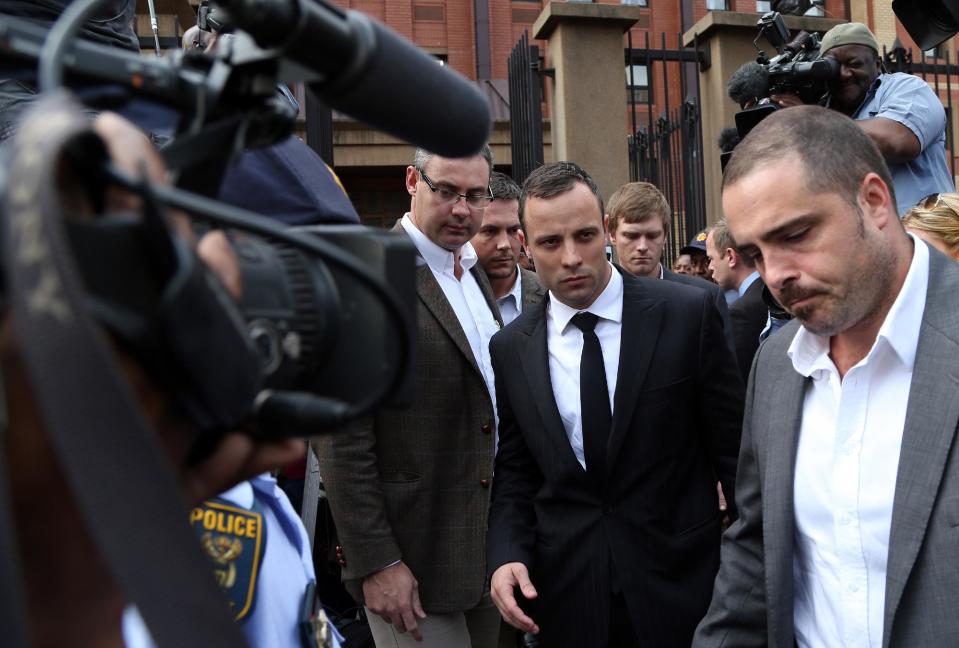 Oscar Pistorius, center, leaves the high court in Pretoria, South Africa, Wednesday, April 9, 2014. Pistorius is charged with murder for the shooting death of his girlfriend, Reeva Steenkamp, on Valentines Day in 2013. (AP Photo/Themba Hadebe)