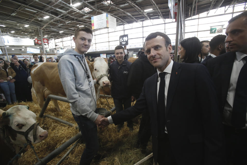 France's President Emmanuel Macron shakes hands with a farmer, Remy Bozon, as he visits the International Agriculture Fair in Paris, France, Saturday, Feb. 23, 2019. Macron pledged Saturday to protect European farming standards and culinary traditions threatened by aggressive foreign trade practices that see food as a "product like any other." (AP Photo/Michel Euler, Pool)