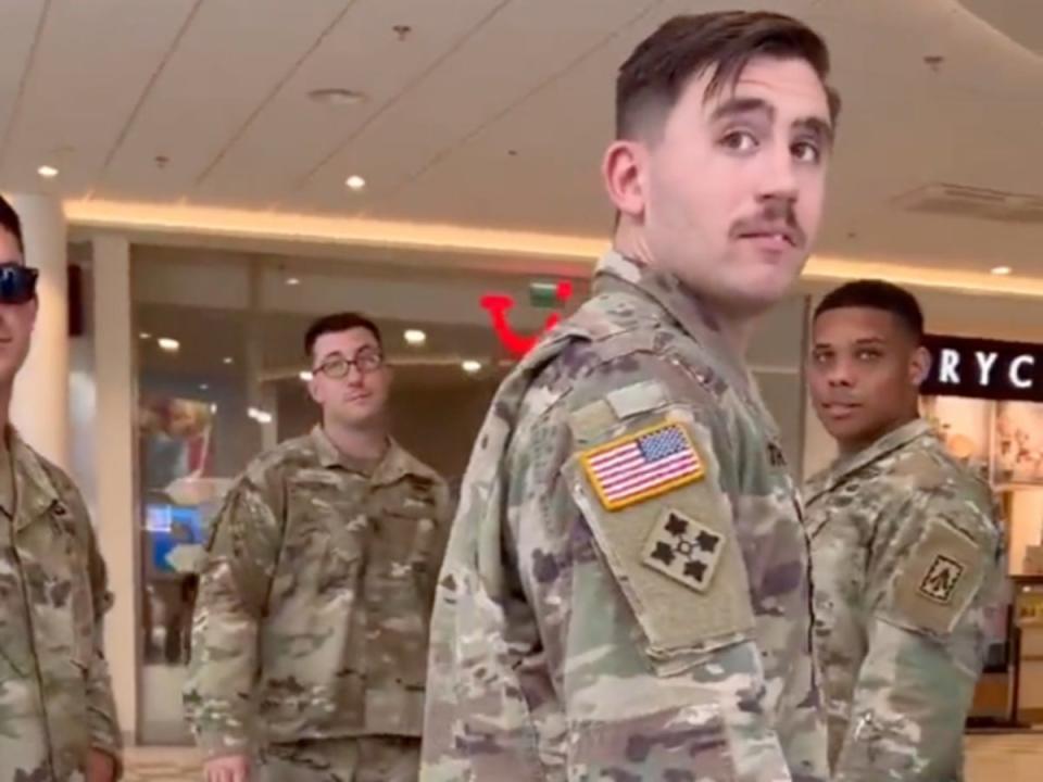 A group of US soldiers looks back as a man filming them hurls slurs and insults at them (screengrab/Twitter/Havoc_Six)