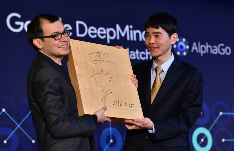 Google Deepmind chief Demis Hassabis (left) was presented with a signed Go board by South Korean grandmaster Lee Se-Dol during a ceremony in Seoul, on March 15, 2016