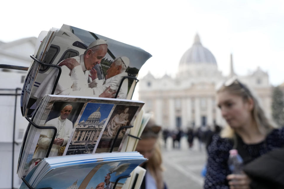 People look postcards showing Pope Francis and Pope Emeritus Benedict XVI in Rome, near the Vatican, Wednesday, Dec. 28, 2022. The health of Pope Emeritus Benedict XVI has worsened due to his age, and doctors are constantly monitoring the 95-year-old's condition, the Vatican said Wednesday. (AP Photo/Alessandra Tarantino)