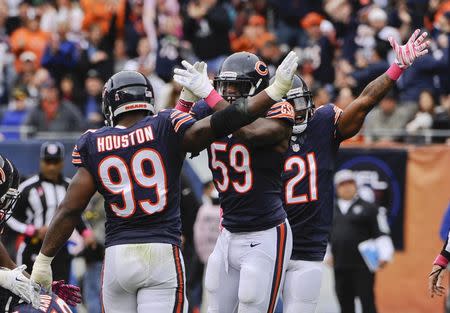 Oct 4, 2015; Chicago, IL, USA; Chicago Bears linebacker Lamarr Houston (99), inside linebacker Christian Jones (59) and strong safety Ryan Mundy (21) celebrate after a fumble was recovered by defensive end Sam Acho (49) in the second half against the Oakland Raiders at Soldier Field. Mandatory Credit: Matt Marton-USA TODAY Sports