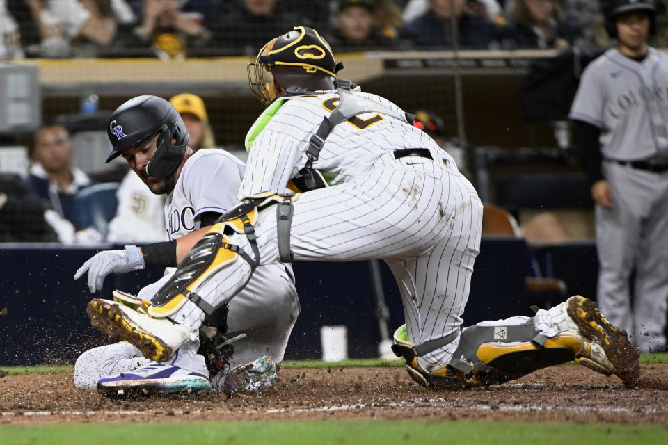 Colorado Rockies' Kris Bryant, left, is tagged out at the plate by San Diego Padres catcher Austin Nola during the eighth inning of a baseball game in San Diego, Thursday, March 30, 2023. (AP Photo/Alex Gallardo)