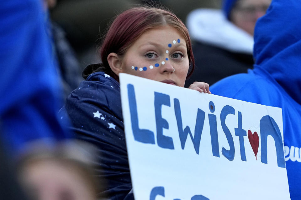 A Lewiston High School fan holds a sign, Wednesday, Nov. 1, 2023, prior to a high school football game against Edward Little High School, in Lewiston, Maine. Locals seek a return to normalcy after a mass shooting on Oct. 25. (AP Photo/Matt York)