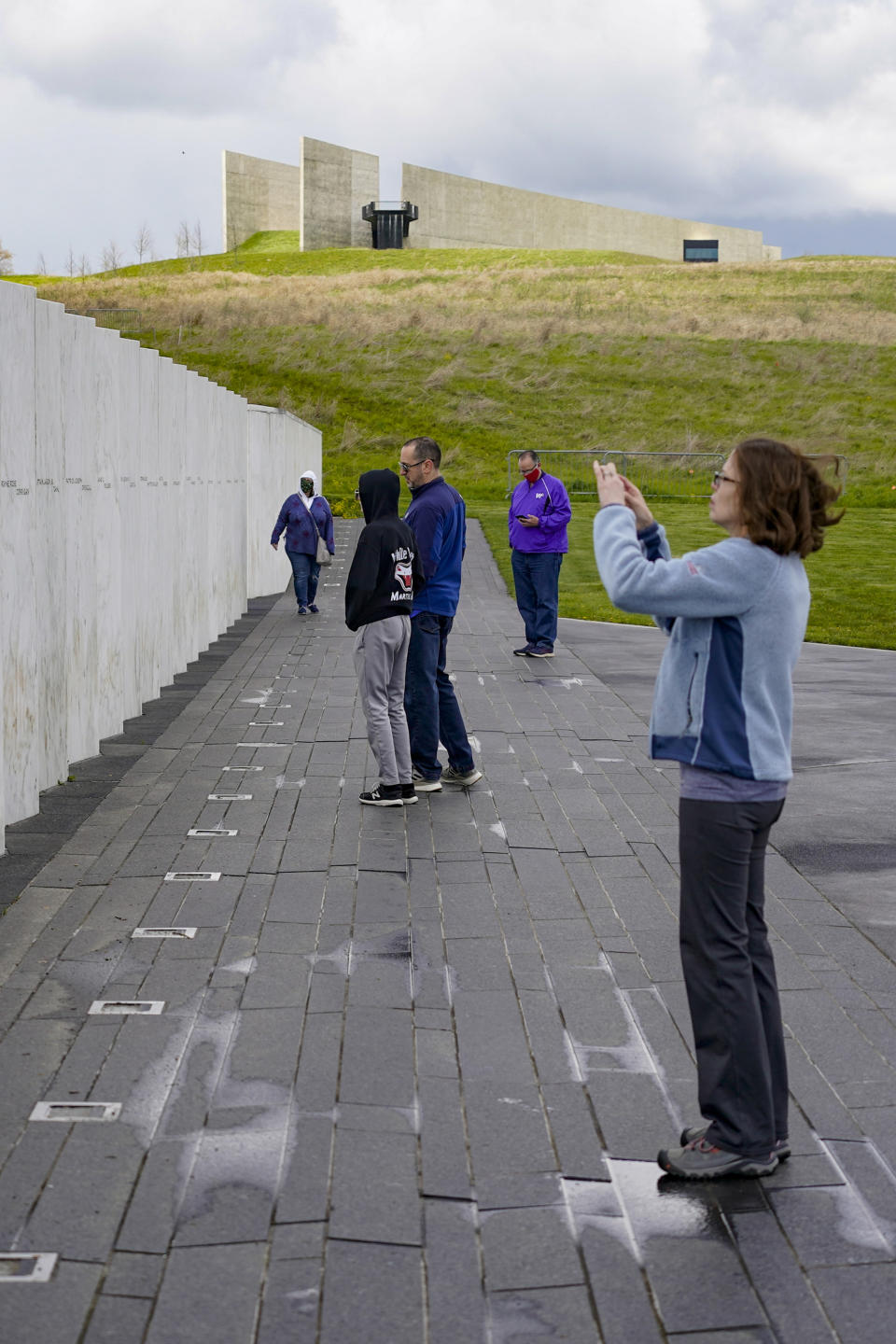 Visitors photograph and look over the Wall of Names at the Flight 93 National Memorial, Saturday, May 8, 2021, in Shanksville, Pa. The organization "Friends of Flight 93" is creating a new annual award for heroism that aims to reward selfless acts of heroism, but also to educate the public on what happened when those aboard hijacked Flight 93 learned of the attacks that had just occurred in New York and Washington D.C. The passengers and crew tried to wrest control of the aircraft they were on, which crashed into a field leaving no survivors. (AP Photo/Keith Srakocic)