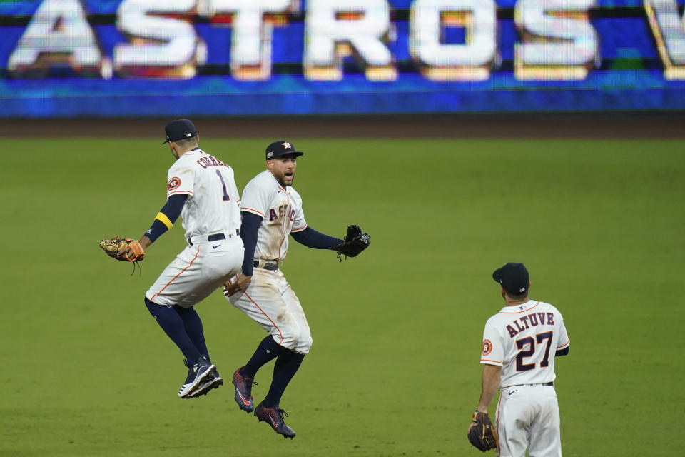 Houston Astros George Springer celebrates with Carlos Correa (1) after Game 4 of a baseball American League Championship Series against the Tampa Bay Rays, Wednesday, Oct. 14, 2020, in San Diego. The Astros defeated the Rays 4-3 and the Rays lead the series 3-1 games. (AP Photo/Gregory Bull)