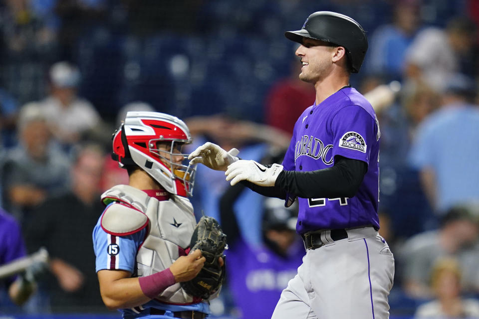 Colorado Rockies' Ryan McMahon, right, celebrates past Philadelphia Phillies catcher Rafael Marchan after hitting a two-run home run against pitcher Ian Kennedy during the ninth inning of a baseball game, Thursday, Sept. 9, 2021, in Philadelphia. (AP Photo/Matt Slocum)